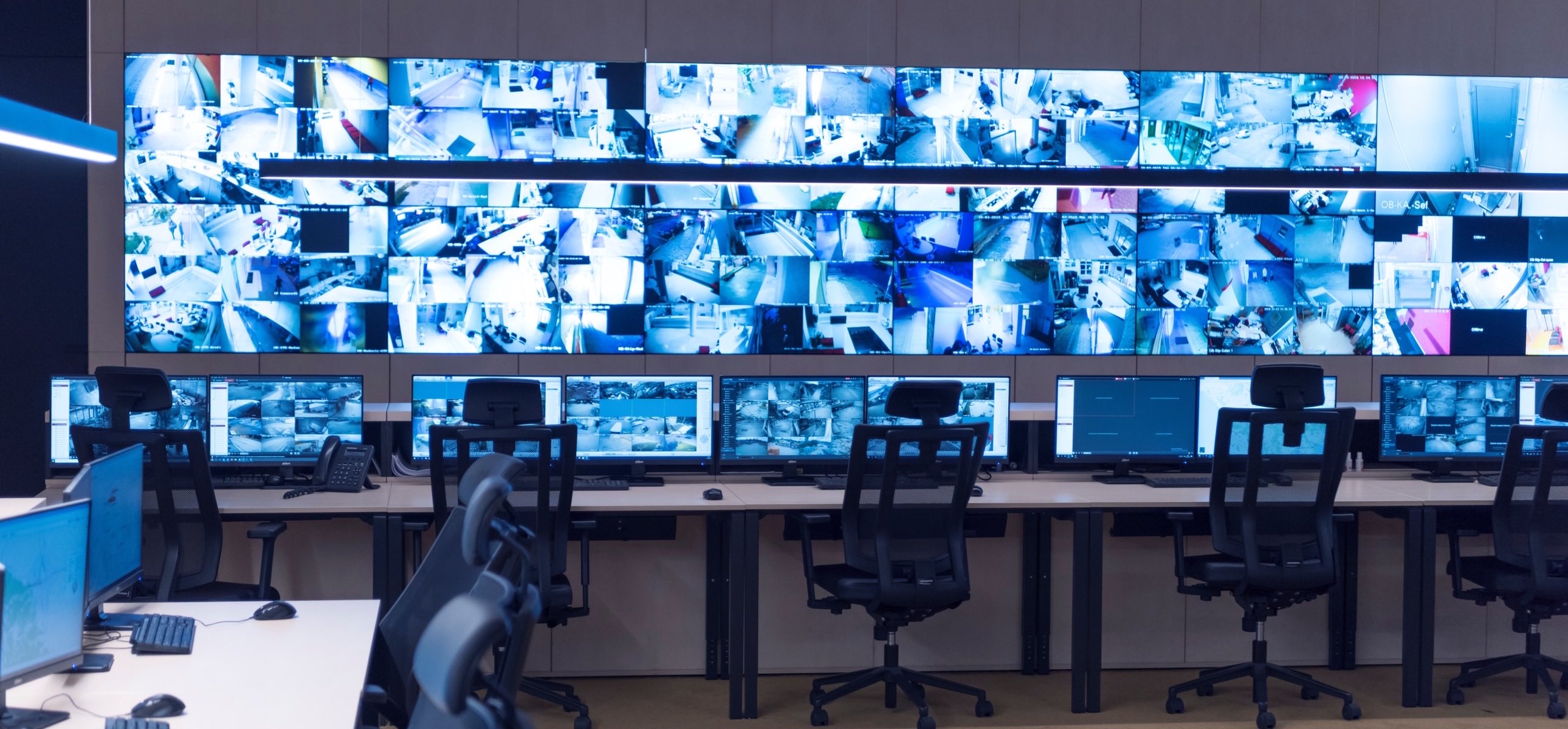 Security operator monitoring live CCTV camera feeds in a control room